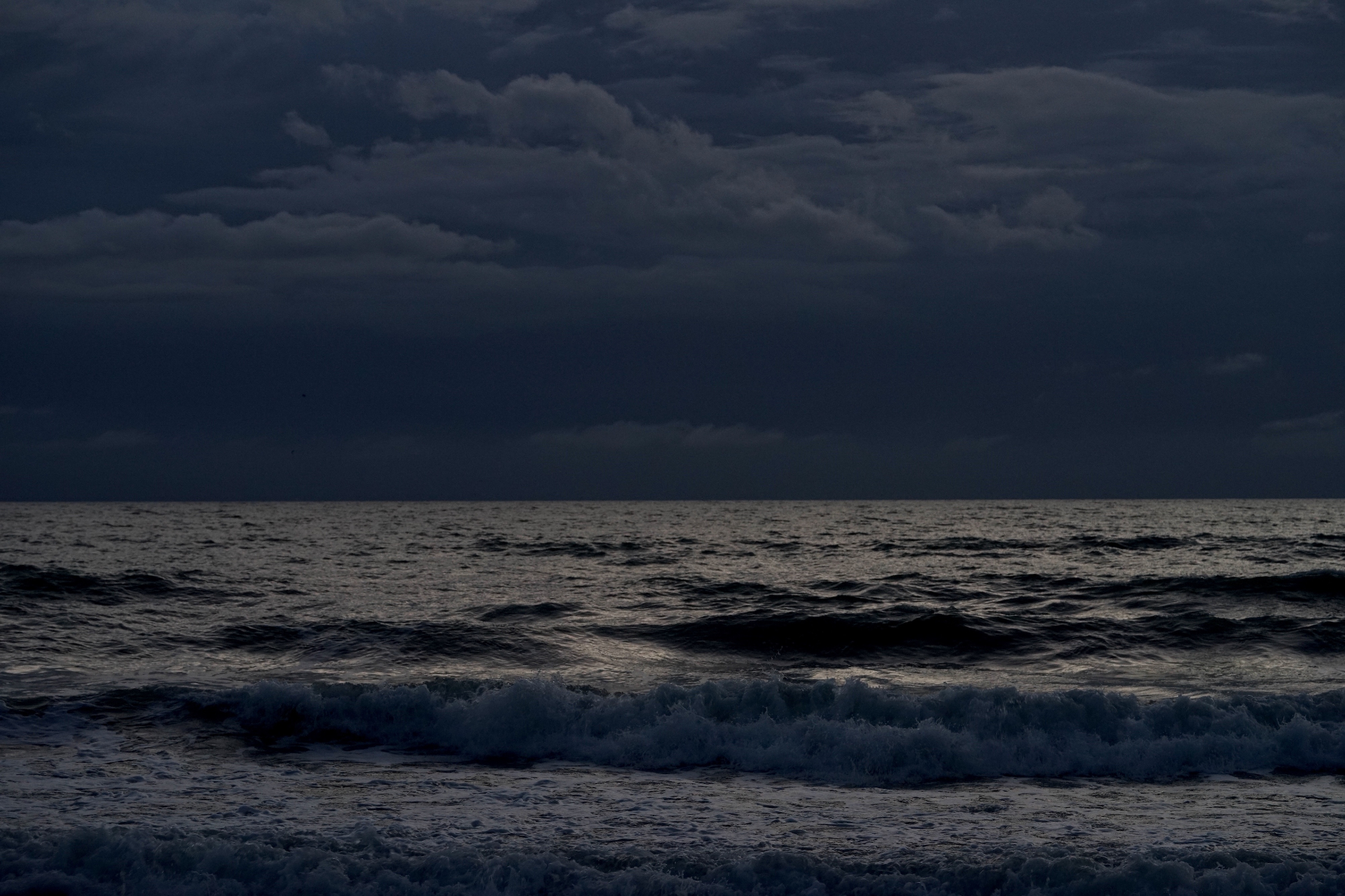 Offshore squall over dark Atlantic waves under heavy clouds